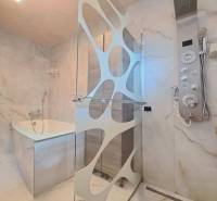 Badezimmer mit moderner Dusche, Badewanne und Designerbeleuchtung in einem Einfamilienhaus.