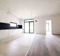 Eine geräumige Küche in einem Einfamilienhaus mit einem Holzboden und großen Fenstern.