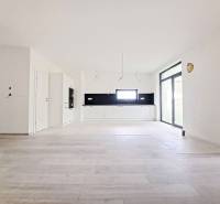 Geräumige Küche mit schwarzen Fliesen und Boden in Holzoptik in einem Einfamilienhaus.