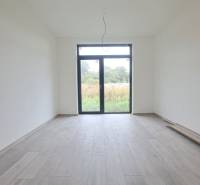 Innenraum eines Einfamilienhauses mit Holzboden und großem Fenster.