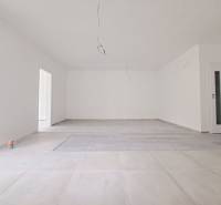 Ein geräumiger Raum mit einem Holzboden und weißen Wänden in einem Einfamilienhaus.