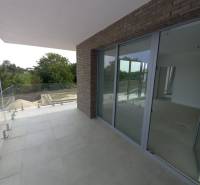 Balkon einer 2-Zimmer-Wohnung in Galanta mit Fliesen und Verglasung, umgeben von Grün.