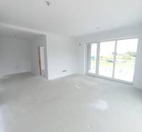 Helles Wohnzimmer in einer 2-Zimmer-Wohnung mit großen Fenstern und leerem Boden.