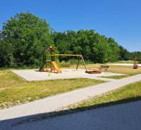 Ein Kinderspielplatz mit Klettergerüsten und Schaukeln in Galanta, umgeben von Grünflächen und Gehwegen.