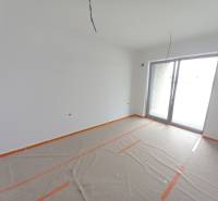 Gewerbefläche mit großem Fenster, weiße Malerei, Boden mit Holzdekor mit Folie abgedeckt.