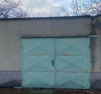 Garagentor mit hellblauen Türen und abgefallenen Blättern in Selice.