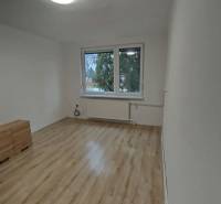 Helles Zimmer mit Holzboden und Fenster in einer 3-Zimmer-Wohnung.