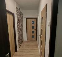 Ein Flur mit hellem Boden und Holztüren in einer 3-Zimmer-Wohnung.