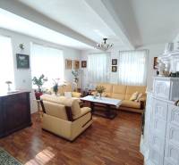 Wohnzimmer eines Einfamilienhauses mit Holzboden, Kamin und bequemer Sitzgarnitur.