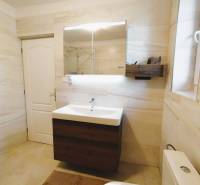 Ein Badezimmer in einem Einfamilienhaus mit weißen Wänden und einem Waschbecken mit Spiegel.