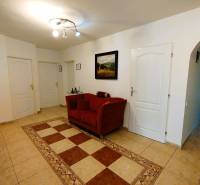 Ein Flur in einem Einfamilienhaus mit einem roten Sessel und Fliesen.