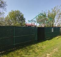 Grundstück mit Grünflächen in den Gärten in Šaľa, sonniger Tag mit blauem Himmel.