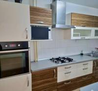 Küche mit Steinspüle, Kochfeld und Dunstabzugshaube in einer 4-Zimmer-Wohnung.