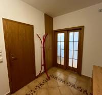 Flur einer 3-Zimmer-Wohnung mit Fliesenboden und Holztüren.