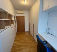 Ein Arbeitszimmer mit weißen Möbeln, Einbauschränken und einem Boden in Holzoptik in einer 3-Zimmer-Wohnung.