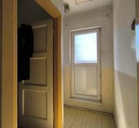 Flur in einem Einfamilienhaus mit hellem Eingang und Holzboden.