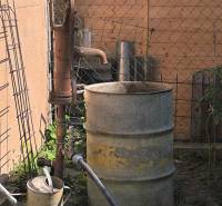 Wasserpumpe mit einem Metallfass im Garten eines Einfamilienhauses in Partizánske.