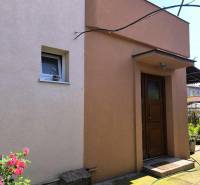 Ein Einfamilienhaus in Partizánske mit farbigem Putz und Garten.