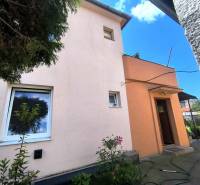 Das Einfamilienhaus in Partizánske hat eine rosa Fassade, kleine Fenster und eine Eingangstür.