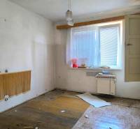 Notwendige Renovierung des Zimmers im Einfamilienhaus, wobei das natürliche Licht aus dem Fenster erhalten bleibt.