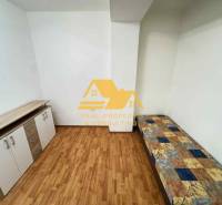 Ein Zimmer in einer 3-Zimmer-Wohnung mit einem Bett, einer Kommode und einem Boden in Holzoptik.