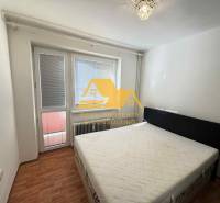 Schlafzimmer in einer 3-Zimmer-Wohnung mit Bett, Fenster und Boden in Holzoptik.