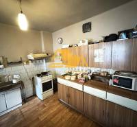 Küche in einem Einfamilienhaus mit Holzdekorboden, Küchenzeile, Geräten, Aufbewahrungsschränken.