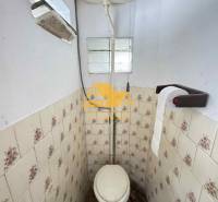 Ein Badezimmer mit älteren Fliesen in einem Einfamilienhaus.