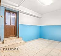 Das Innere eines Einfamilienhauses mit blauen Wänden und hellem Boden neben einer Holztür.