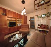 Wohnzimmer in einer 3-Zimmer-Wohnung mit Holzmöbeln und dekorativen Regalen.