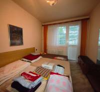 Schlafzimmer in einer 3-Zimmer-Wohnung mit Bett, Bild und großem Fenster mit Aussicht.