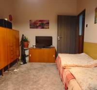 Ein Zimmer in einer 3-Zimmer-Wohnung mit Teppichboden, einem Bett und Holzmöbeln.