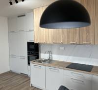 Küche in einer 2-Zimmer-Wohnung mit Holzboden und hellen Möbeln.