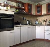 Küche in einem Einfamilienhaus mit Holzboden und hellen Schränken.