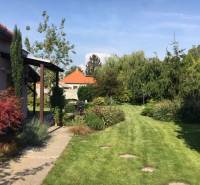 Garten beim Einfamilienhaus in Čierna Voda mit Rasen und Grünflächen.