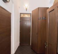 Der Flur einer 2-Zimmer-Wohnung mit dunklen Türen und Einbauschränken.