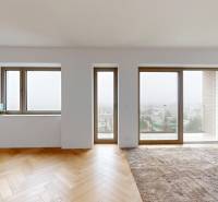 Innenraum eines Einfamilienhauses mit großen Fenstern und einem Boden in Holzoptik.