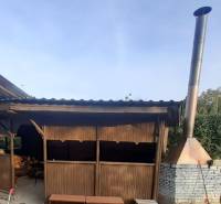 Holzpavillon und gemauerter Kamin bei der Hütte in Pozdišovce.