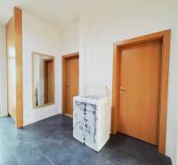 Der Flur in einer 2-Zimmer-Wohnung mit dunklem Boden und Holztüren.