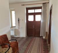 Der Flur eines Einfamilienhauses mit Fliesenboden, einem Sessel und einem Vorhang.