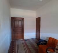 Interieur eines Einfamilienhauses mit Türen, einem Sessel und einem Teppichläufer.