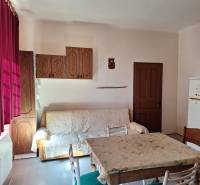 Innenraum eines Einfamilienhauses mit Sofa, Esstisch und Holzschränken.