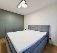 Ein stilvolles Schlafzimmer in einer 3-Zimmer-Wohnung mit Holzboden und moderner Beleuchtung.
