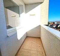 Der Balkon einer 4-Zimmer-Wohnung mit Blick auf die Dächer der Häuser und einen klaren Himmel.