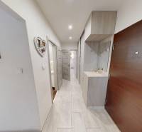 Der Flur in der 2-Zimmer-Wohnung mit einer Garderobenwand und weißen Wänden.