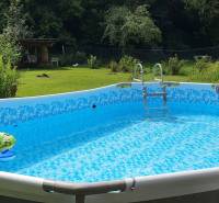 Ein aufblasbares Schwimmbecken im Garten der Hütte, umgeben von Grün auf der Hviezdoslavova Straße in Tisovec.