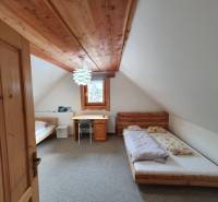 Ein Zimmer in einer Hütte mit einer Holzdecke, zwei Betten und einem Tisch.