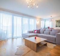 Wohnzimmer in einem Einfamilienhaus mit geräumigem Sofa und Boden in Holzoptik.