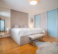 Schlafzimmer im Einfamilienhaus mit Bett, Holzboden und Fellteppich.