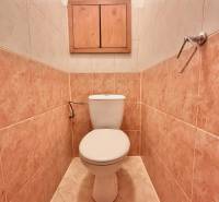 Badezimmer mit Fliesen und einem Holzschrank in einer 3-Zimmer-Wohnung.